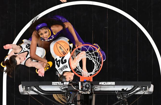 An overhead view of Angel Reese of the LSU Lady Tigers and Caitlin Clark and Gabbie Marshall of the Iowa Hawkeyes vie for position under the basket during the 2023 NCAA Women's Basketball Tournament National Championship.