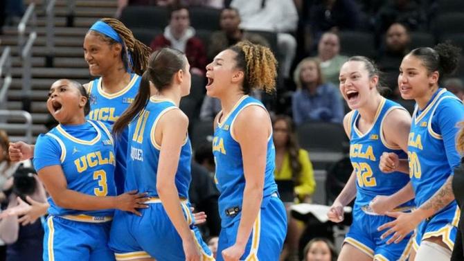 The UCLA women’s basketball team celebrates a win.