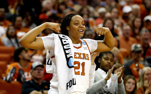 Texas women’s basketball forward Aaliyah Moore flexes from the sidelines.