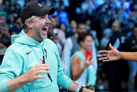 Jason Sudeikis laughs on the sidelines while wearing a seafoam-colored WNBA hoodie.
