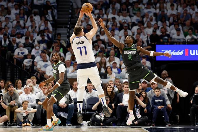 Luka Dončić #77 of the Dallas Mavericks shoots the ball against Anthony Edwards #5 of the Minnesota Timberwolves.