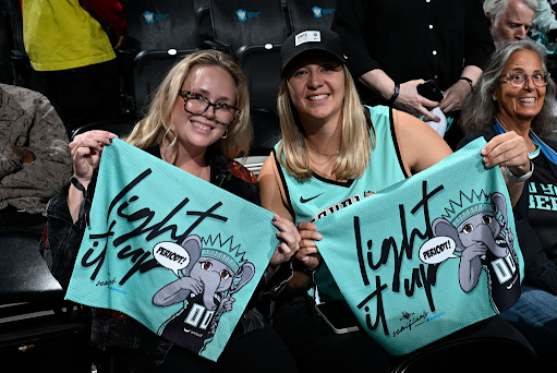 NY Liberty fans pose at a game.