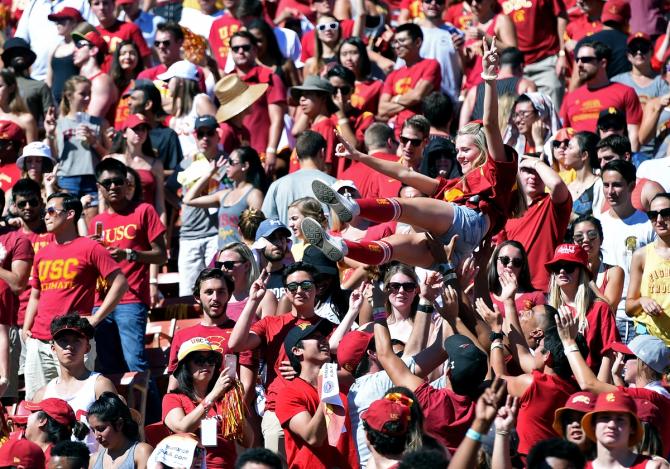 USC student fans lift up a female student to count the number of points on the board after a touchdown during an NCAA football game