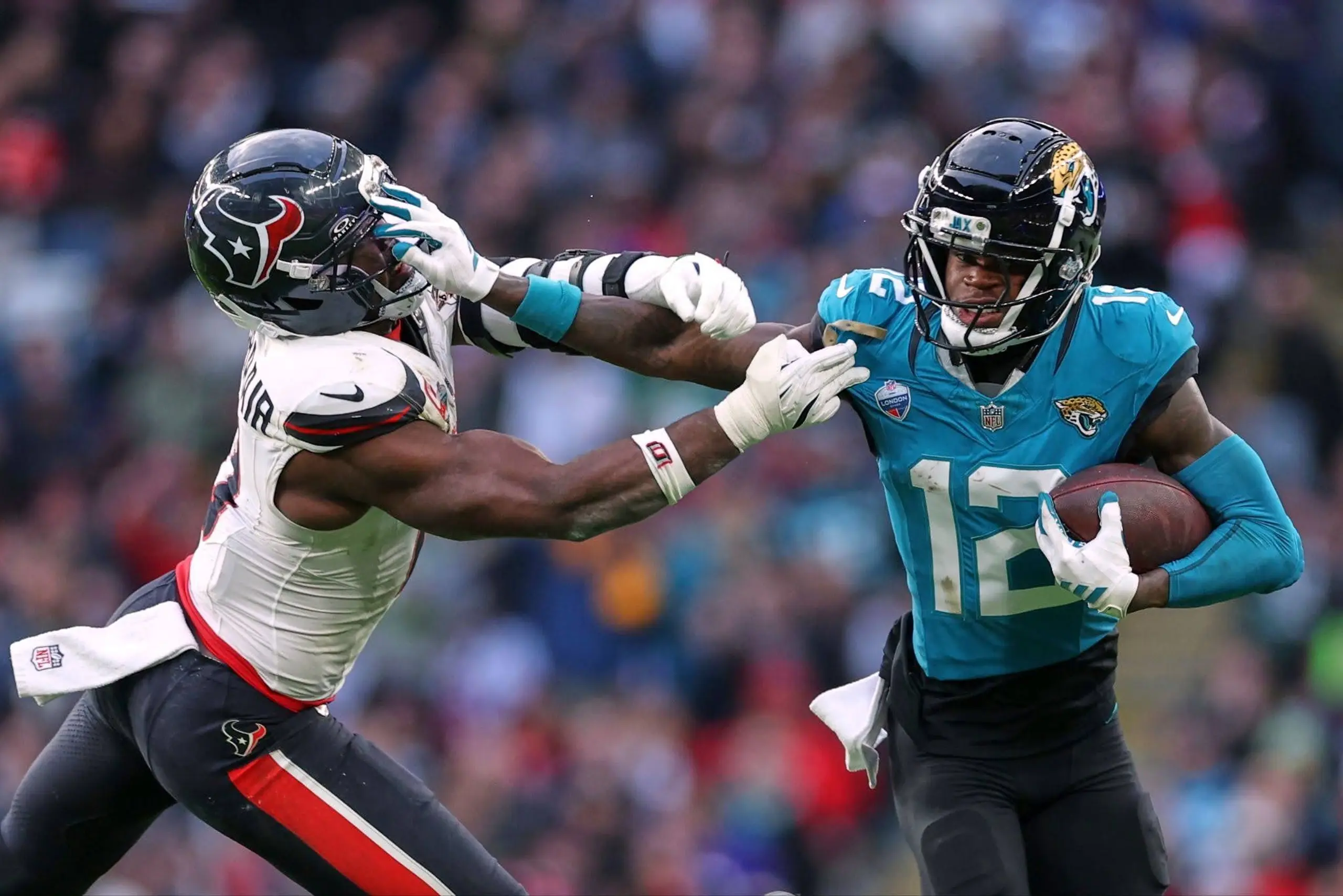 Jacksonville Jaguars star Travis Hunter stiffarms a Houston Texans linebacker Azeez al-Shaair.