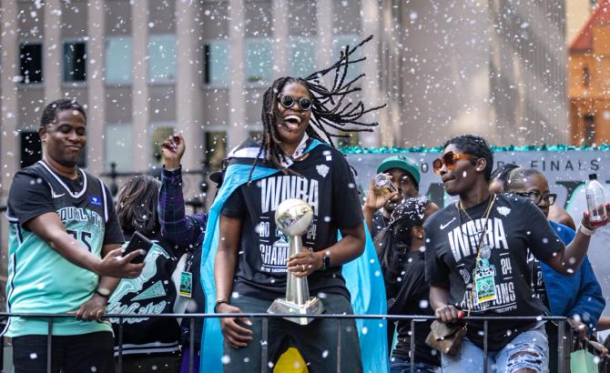 The NY Liberty’s Jonquel Jones holds the MVP trophy during the ticker-tape parade honoring the team as WNBA Champions.