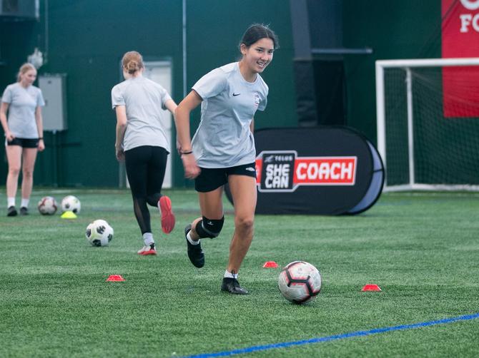 A soccer player kicking a soccer ball