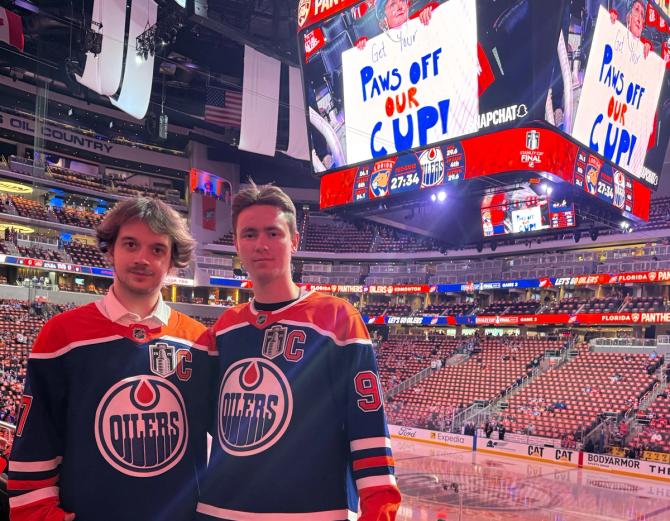 Two men posing in Edmonton Oilers jerseys