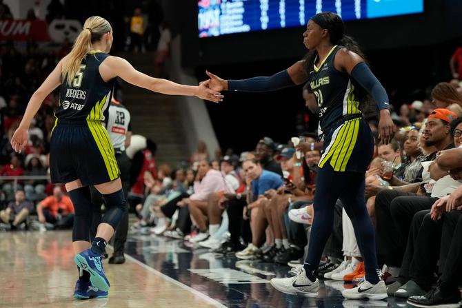 Paige Bueckers and Arike Ogunbowale high fiving on the court