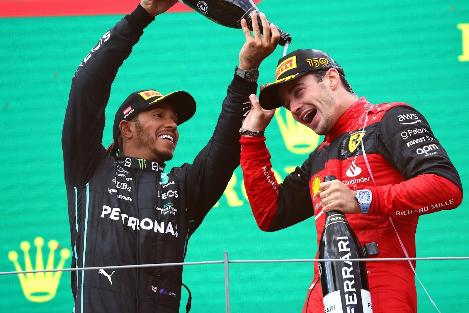 Mercedes driver Lewis Hamilton celebrating on the podium with Ferrari driver Charles Leclerc. 