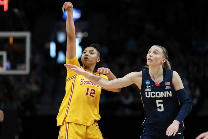 JuJu Watkins and Paige Bueckers watch a shot during their Elite Eight matchup on April 01, 2024, in Portland, Oregon.