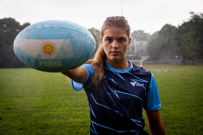 A girl holding a rugby ball on the field