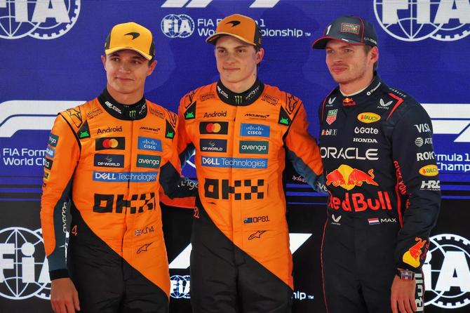 McLaren teammates Lando Norris and Oscar Piastri stand beside Red Bull’s Max Verstappen.