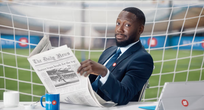 Lamorne Morris looking on while holdling a newspaper