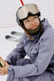British skier Zoe Atkin holds a sandwich on the slope.