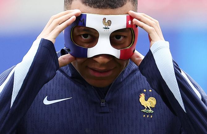 France's forward #10 Kylian Mbappe adjusts his face mask as he takes part in a MD-1 training session at the Leipzig Stadium