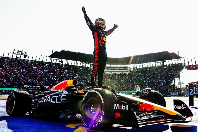 Red Bull driver and current world champion Max Verstappen standing on top of his car after winning the 2023 Mexico Grand Prix.