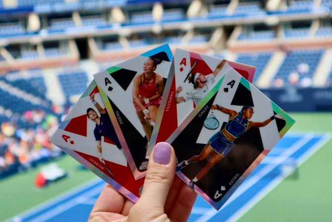 A fan holding four Topps cards