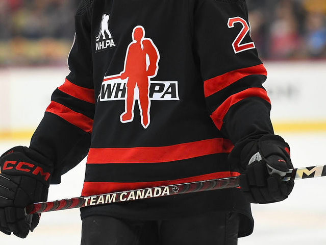 A hockey playing holding a hockey stick