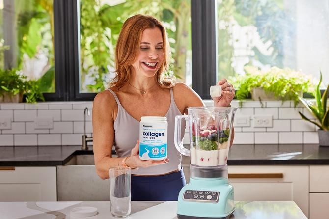 A woman pouring collagen into a blender