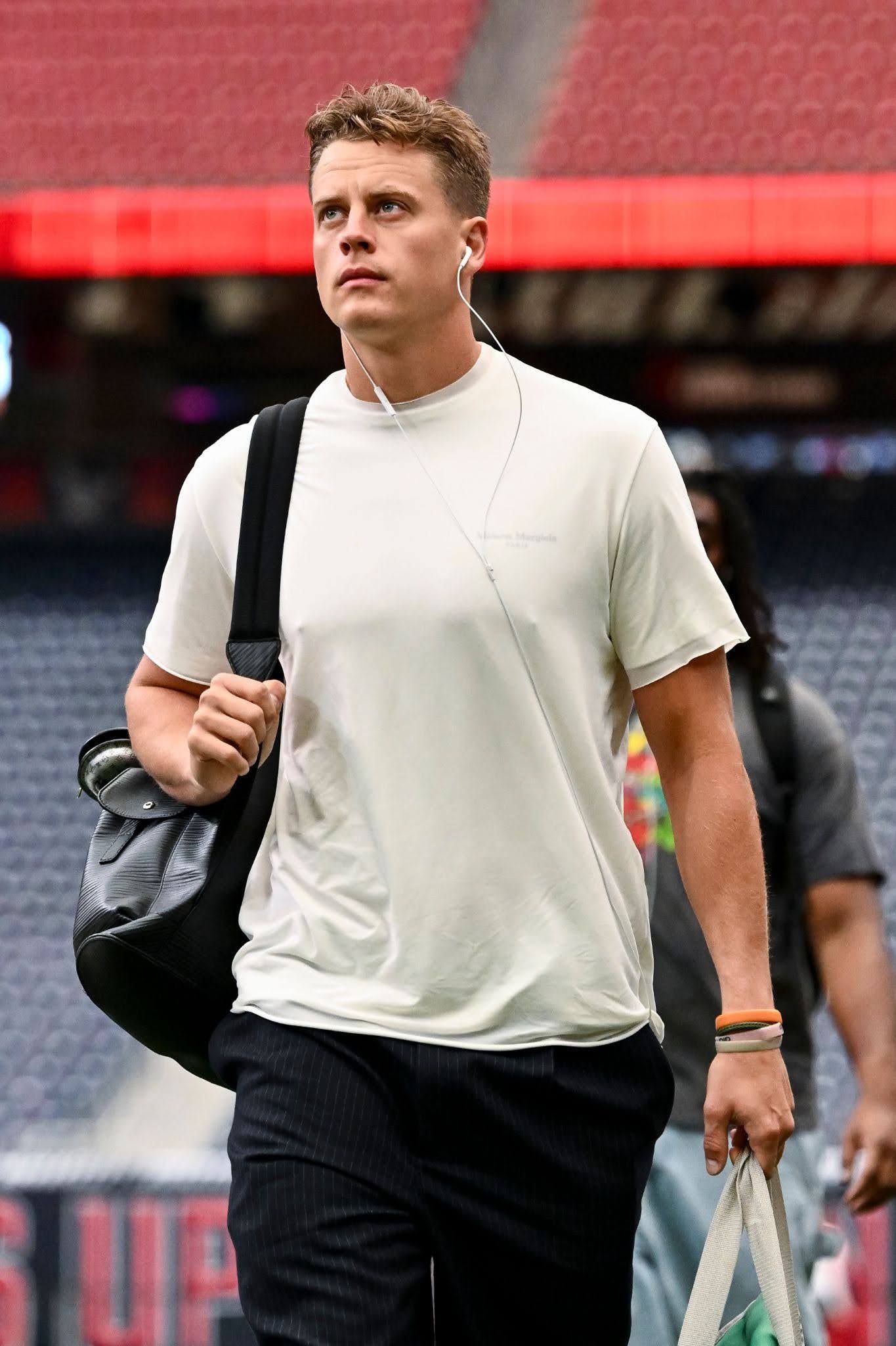 Joe Burrow walks into a stadium wearing a white shirt and black pants ahead of Week 2 of NFL play. 
