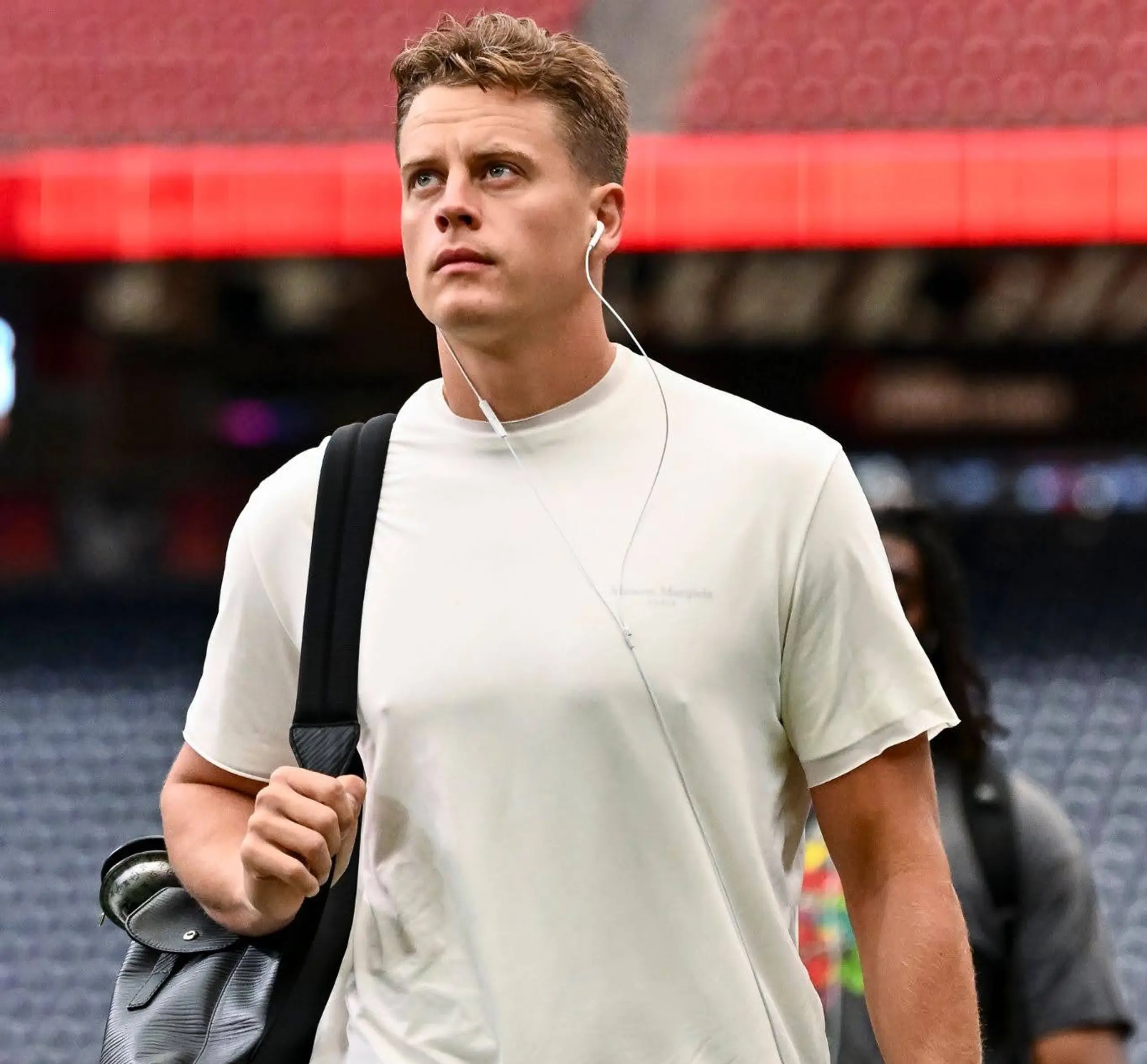 Joe Burrow walks into a stadium wearing a white shirt and black pants ahead of Week 2 of NFL play.