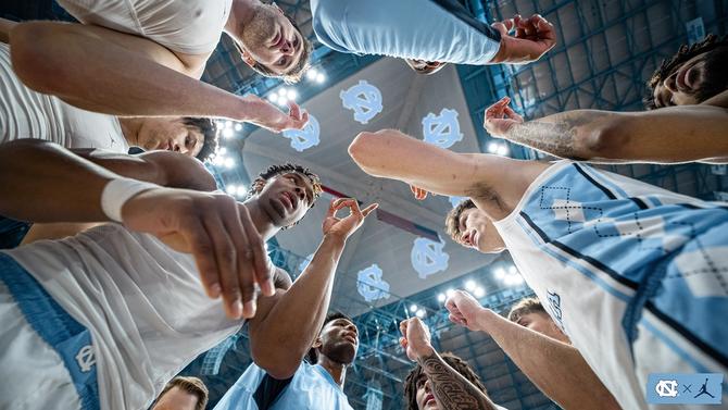 Members of the No. 7 UNC men’s basketball team huddle up before a game.
