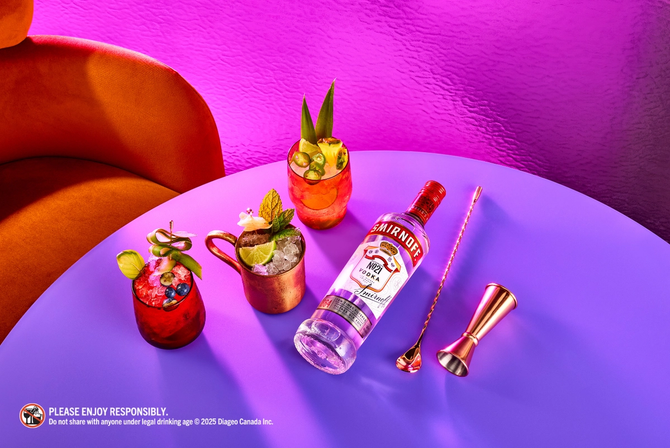 A bottle of Smirnoff vodka next to cocktails