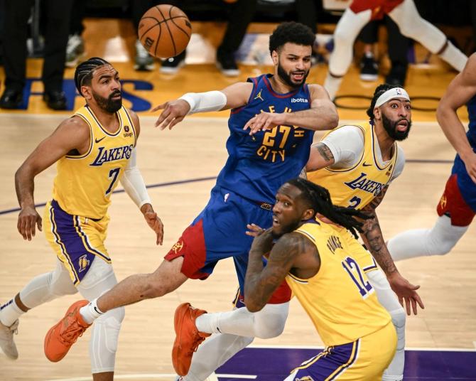 Jamal Murray makes a pass as he is triple-teamed while driving to the rim.