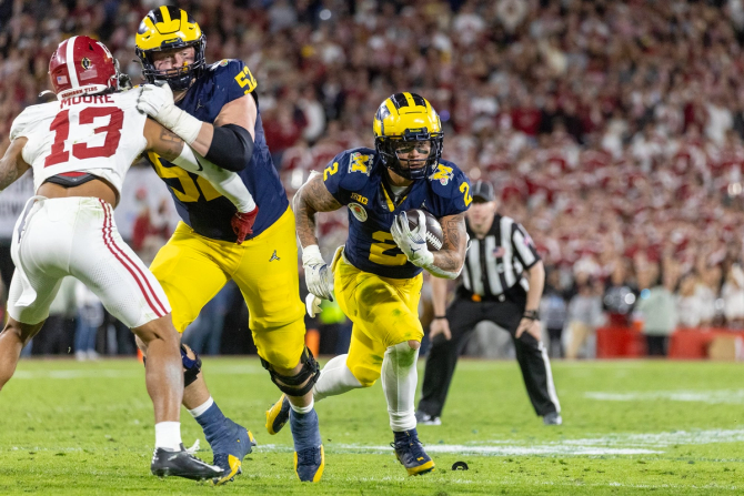 No. 1 Michigan running back Blake Corum weaves around No. 4 Alabama defenders in the Rose Bowl on January 1, 2024.