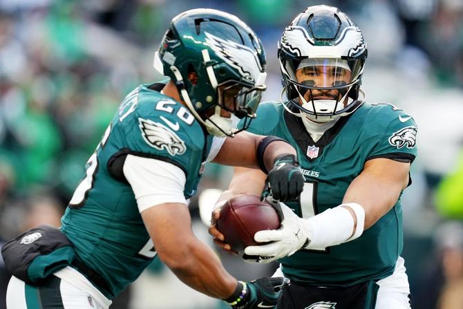 Philadelphia Eagles QB Jalen Hurts hands the ball off to RB Saquon Barkley.