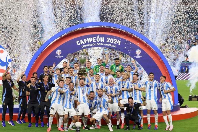 Argentina's forward Lionel Messi lifts up the trophy as he celebrates winning the Conmebol 2024 Copa America tournament final with his team.
