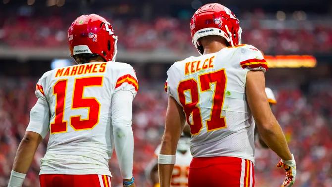 Kansas City Chiefs quarterback Patrick Mahomes and tight end Travis Kelce walk on the field.
