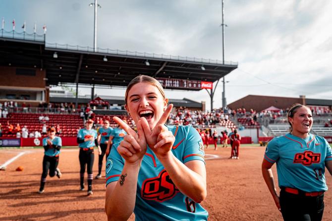 No. 4 Oklahoma State softball catcher Audrey Schneidmiller celebrates her Cowgirls’ huge rivalry win over No. 2 Oklahoma by flashing a W with her hands.