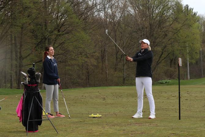 The GIST co-founder Ellen Hyslop looking on as PGA golf pro Emma de Groot gives her lessons