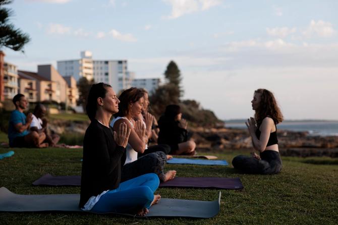 People taking a yoga class in the outdoors