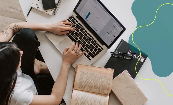 An overhead view of a woman typing on her laptop