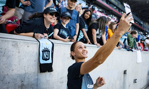 Former Gotham FC player Lynn Williams poses with fans.