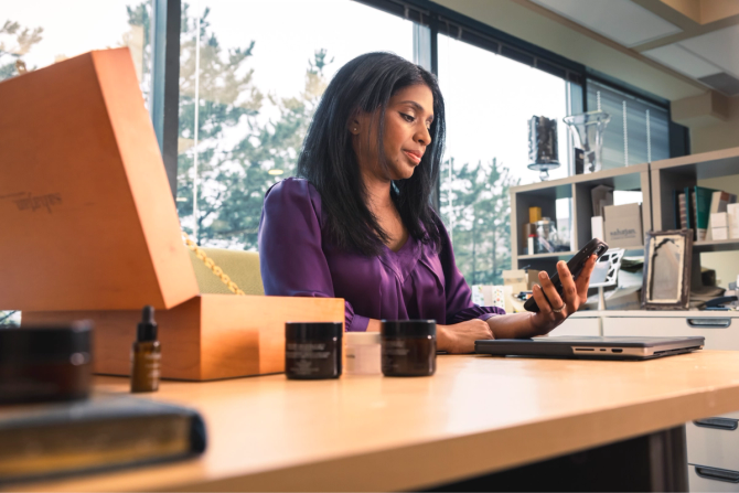 A woman checking her phone while sitting at her desk