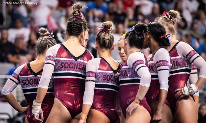 The Oklahoma women’s gymnastics team huddles at a 2023 meet.
