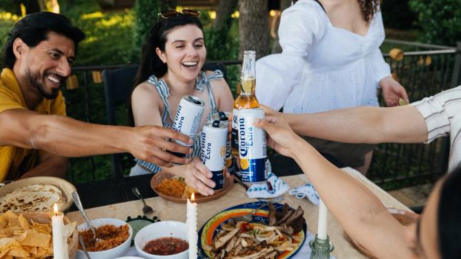 A group of people enjoying Corona drinks over a meal