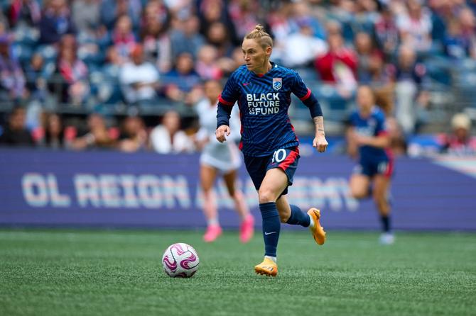 OL Reign midfielder Jess Fishlock dribbles.