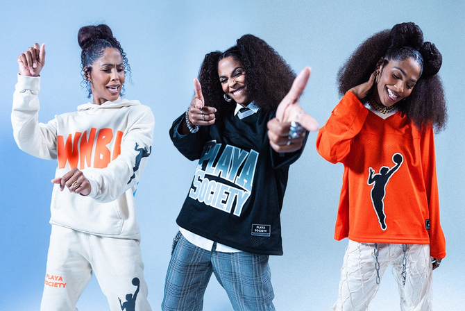 A woman posing in Playa Society merch