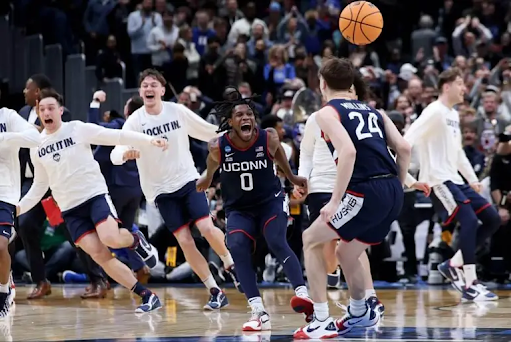 The UConn men’s basketball team celebrates Braylon Mullins’ buzzer-beater.