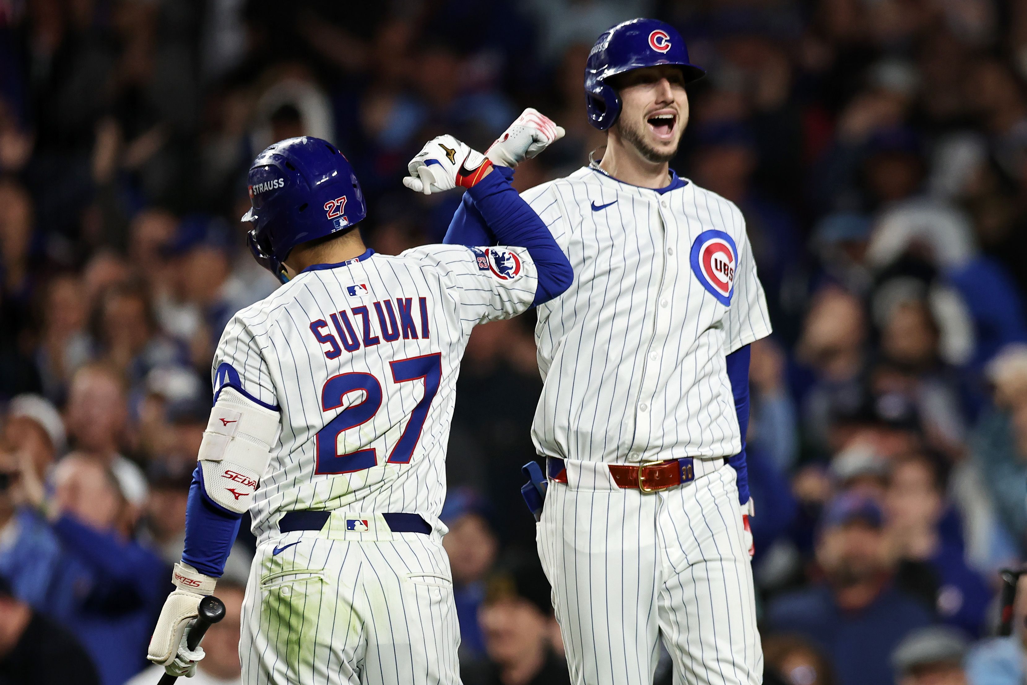 Seiya Suzuki #27 and Kyle Tucker #30 of the Chicago Cubs celebrate after Tucker hit a home run during the seventh inning against the Milwaukee Brewers 