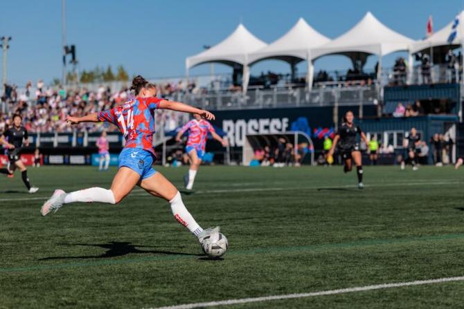 A Montréal Roses player kicks the ball.