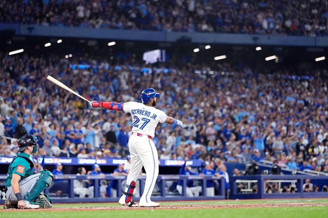 Toronto Blue Jay Vladdy Guerrero Jr. watches the ball fly as fans react.
