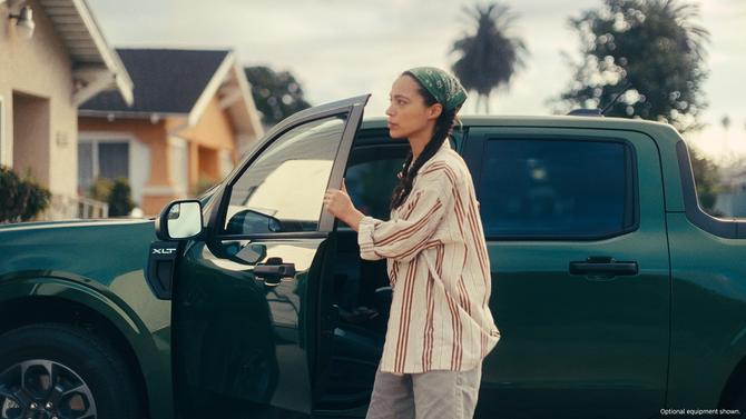 A woman holding a car door open