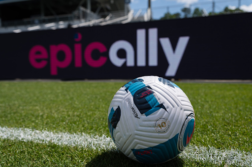 An NWSL soccer ball sits on the sideline of a field.