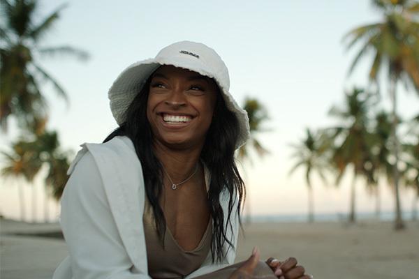 Simone Biles smiling at the beach