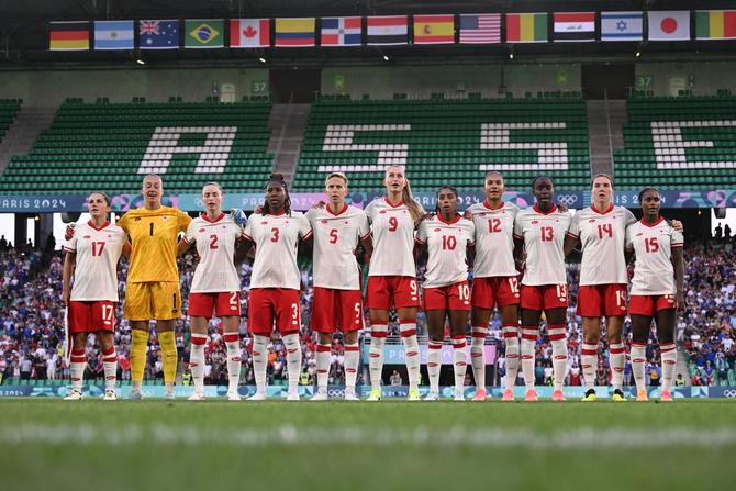 Team Canada sings their national anthem on the pitch.